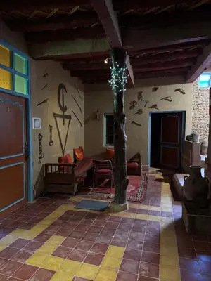 a living room with a wall with a tree in it at GITE LA GROTTE VALLEE in Aoûtouss