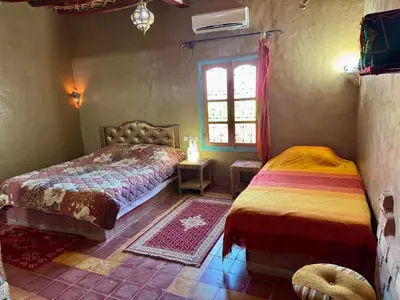 a bedroom with two beds and a window at GITE LA GROTTE VALLEE in Aoûtouss