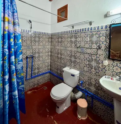 a bathroom with a toilet and a sink at GITE LA GROTTE VALLEE in Aoûtouss
