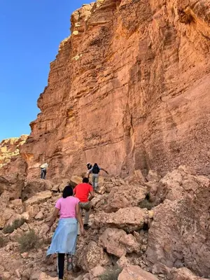 a group of people climbing up a rocky mountain at GITE LA GROTTE VALLEE in Aoûtouss