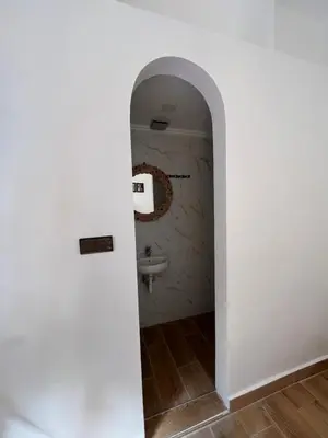 a hallway leading to a bathroom with a sink at Rose Garden Dades in Iqouassene