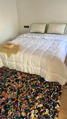 a bedroom with a bed with a rug on the floor at Rose Garden Dades in Iqouassene