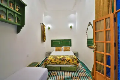 a bedroom with two beds and a door at Dar Usham Fes Luxury Guest House in Fès