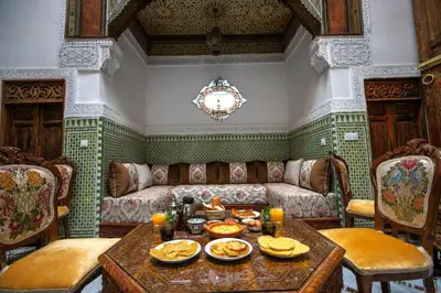 a living room with a couch and a table with food on it at Dar Usham Fes Luxury Guest House in Fès