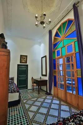 a room with a colorful door and a table at Dar Usham Fes Luxury Guest House in Fès