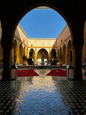 an archway in a building with tables and chairs at Dar Hassan Merzouga in Merzouga