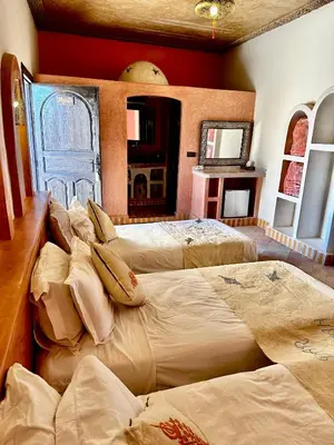 a room with three beds with pillows on them at Dar Hassan Merzouga in Merzouga