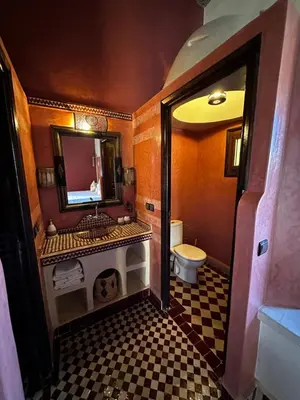a bathroom with a sink and a toilet and a mirror at Dar Hassan Merzouga in Merzouga