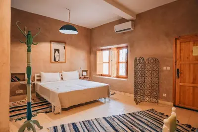 a bedroom with a bed and a rug at RIAD AMAN SKOURA in Skoura