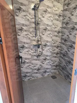 a bathroom with a shower with a marble wall at Camp Bivouac Hassi Smara in Tâlhâ