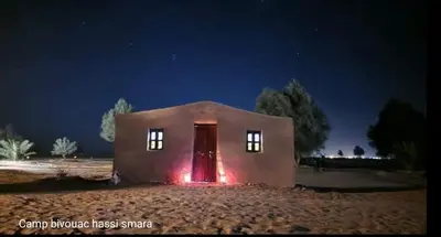 a small house with a red light in the night at Camp Bivouac Hassi Smara in Tâlhâ