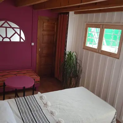 a bedroom with a white bed and a purple wall at DAR ORANGE in Fès