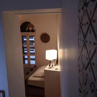a bedroom with a bed and a lamp on a dresser at DAR ORANGE in Fès