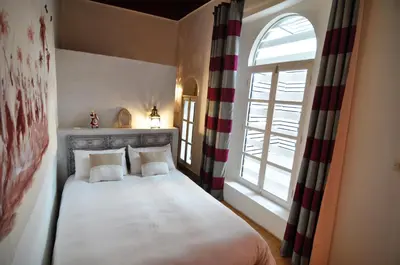 a bedroom with a bed with two pillows and a window at DAR ORANGE in Fès