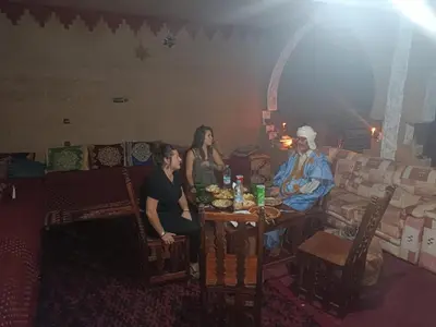 a group of people sitting at a table in a room at Auberge chez hammadi in Zagora
