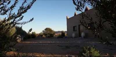 a house in the middle of a field with a building at Auberge chez hammadi in Zagora