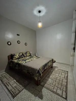 a bedroom with a bed in the corner of a room at Chez Siham in Fès