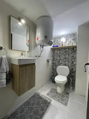 a bathroom with a toilet and a sink and a mirror at Chez Siham in Fès