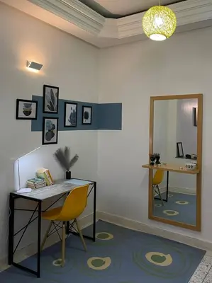 a room with a table and two chairs and a mirror at Chez Siham in Fès