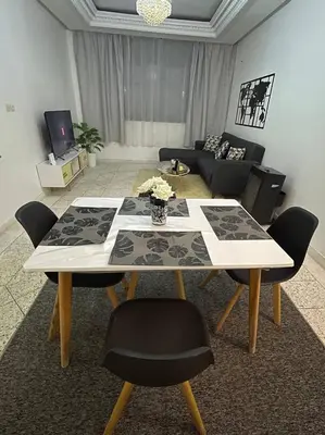 a living room with a table with chairs and a couch at Chez Siham in Fès