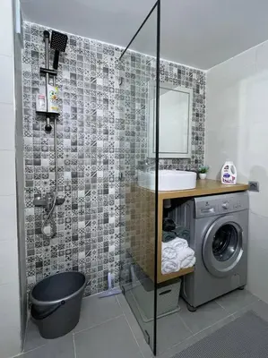 a bathroom with a sink and a washing machine at Chez Siham in Fès