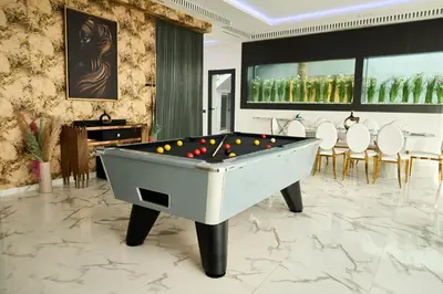 a billiard table in a room with chairs at Villa moderne Marrakech in Marrakech