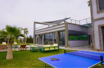 a house with a ping pong table in the yard at Villa moderne Marrakech in Marrakech
