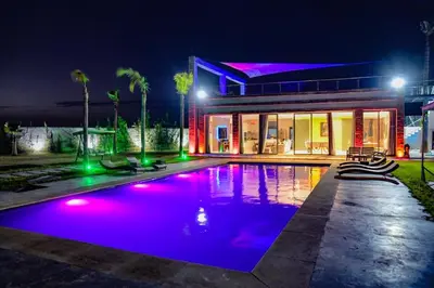 a house with a swimming pool at night at Villa moderne Marrakech in Marrakech