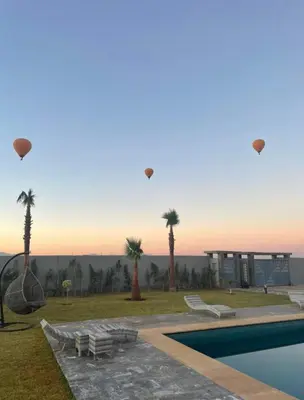 a group of kites flying in the sky over a pool at Villa moderne Marrakech in Marrakech