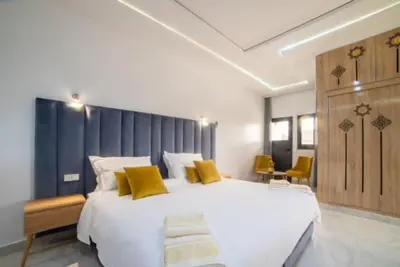 a bedroom with a large white bed with yellow pillows at RIAD GOLD in Azrou