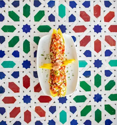a white plate topped with a corn dog on a table at RIAD GOLD in Azrou