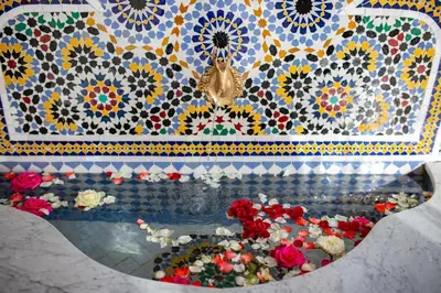 a room with a mosaic wall with flowers and a fountain at RIAD GOLD in Azrou