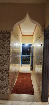 a hallway with a red carpet and a window at Ighbola Ouzoud in Ouzoud
