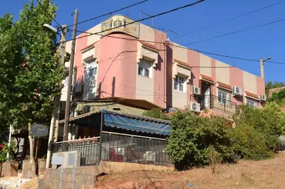 a pink building on the side of a street at Ighbola Ouzoud in Ouzoud
