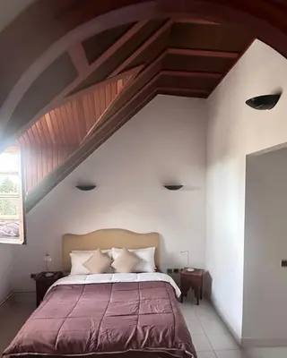 a bedroom with a large bed with a wooden ceiling at Villa jouhara in Ifrane
