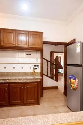 a kitchen with wooden cabinets and a stainless steel refrigerator at Villa jouhara in Ifrane