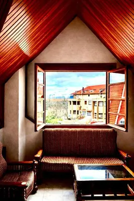 a living room with a couch and a large window at Villa jouhara in Ifrane