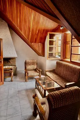 a living room with couches and a table and a fireplace at Villa jouhara in Ifrane