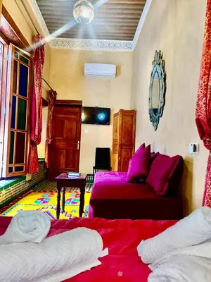 a bedroom with two beds and a couch at Riad Dar Lalj Fes in Fès
