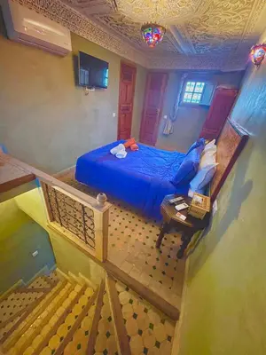 a bedroom with a blue bed and a staircase at Riad Dar Lalj Fes in Fès