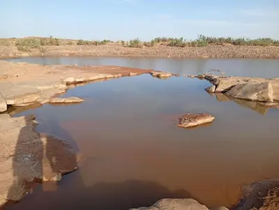 a body of water with rocks in the middle at La Maison-Berbère Mhamid in Mhamid