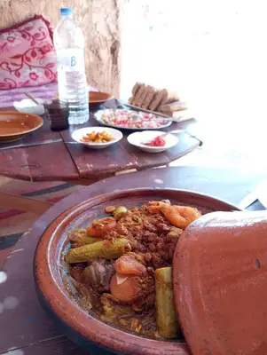 a plate of food on a table with food at La Maison-Berbère Mhamid in Mhamid