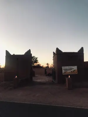a couple of buildings in the middle of a desert at La Maison-Berbère Mhamid in Mhamid