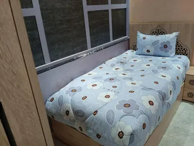 a bedroom with a bed with a flower pattern at Maison Moussaoui in Meknès
