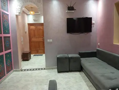 a living room with a couch and a flat screen tv at Maison Moussaoui in Meknès