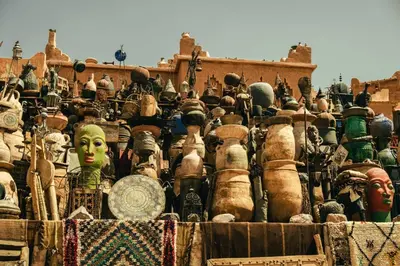 a large pile of masks and statues in front of a building at résidence afgo Ouarzazate in Ouarzazate