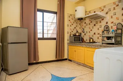 a kitchen with a refrigerator and a window at résidence afgo Ouarzazate in Ouarzazate