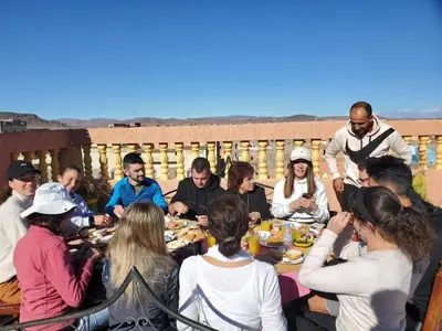 a group of people sitting around a table eating food at résidence afgo Ouarzazate in Ouarzazate