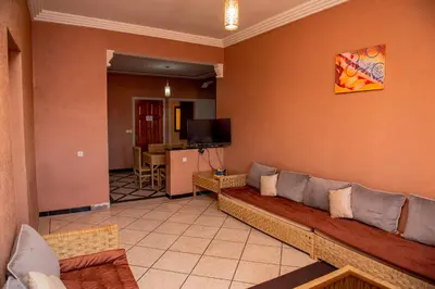 a living room with a couch and a television at résidence afgo Ouarzazate in Ouarzazate