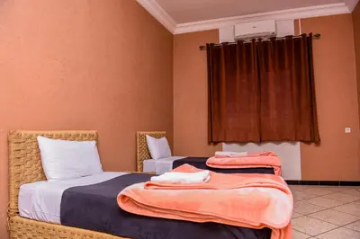 a bedroom with two beds and a window at résidence afgo Ouarzazate in Ouarzazate